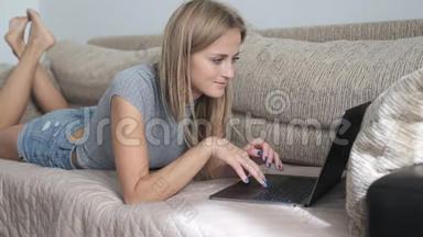 <strong>在</strong>家里用笔记本电脑工作<strong>的女人</strong>。 <strong>躺在沙发上</strong>打字<strong>的女人</strong>